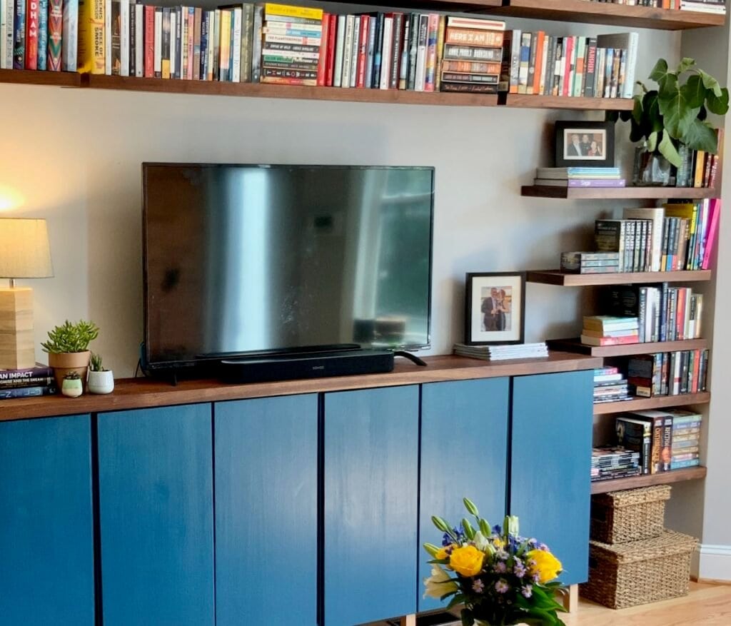 Blue wall mounted cabinet with floating shelves above and on the sides