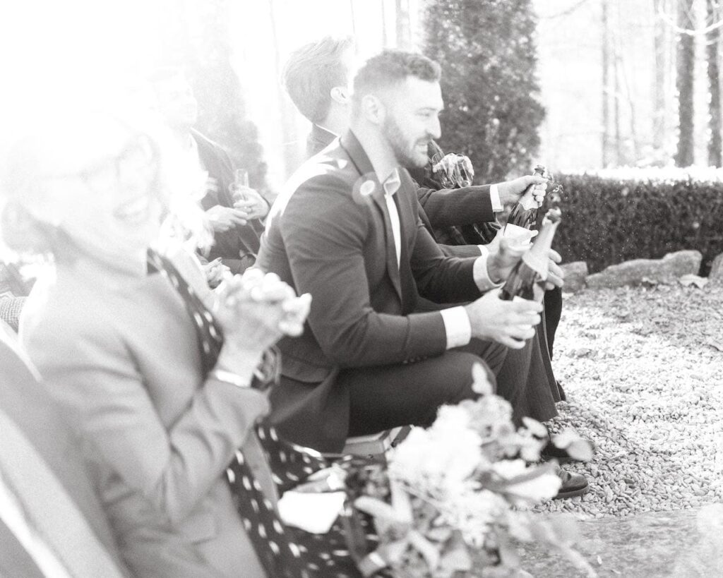 Black & White Image of the Bride's Brothers popping the Champagne Bottles