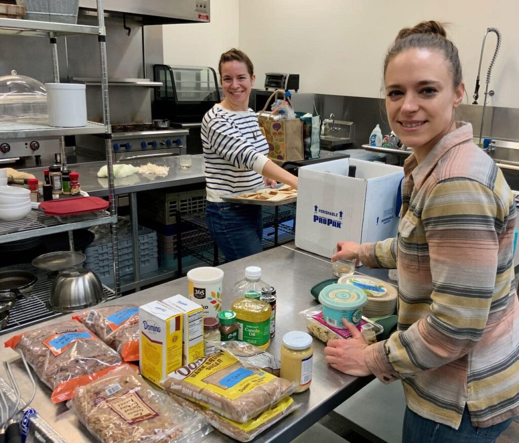 Two women organizing all the ingredients in a commercial kitchen