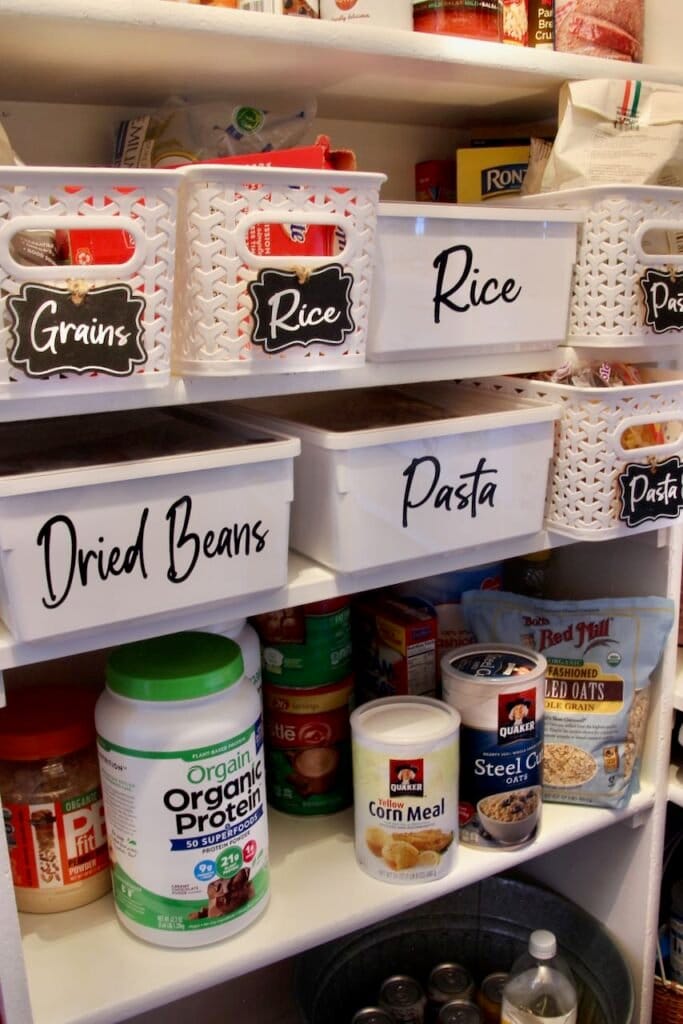 Image of white plastic bins with black labels of "Rice" "Grains" "Pasta" "Pasta" and more "Pasta" on white shelves