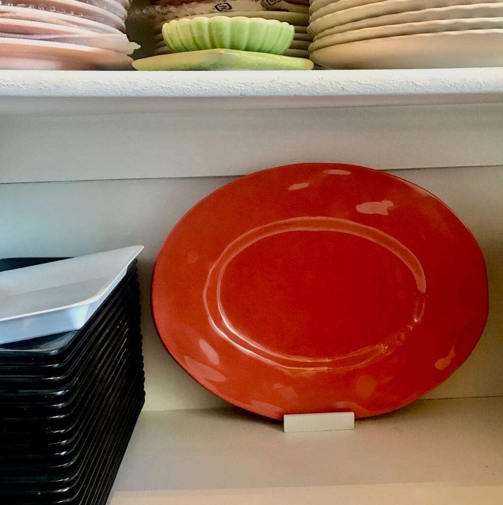 view of the melamine platters standing upright at the back of the pantry shelf