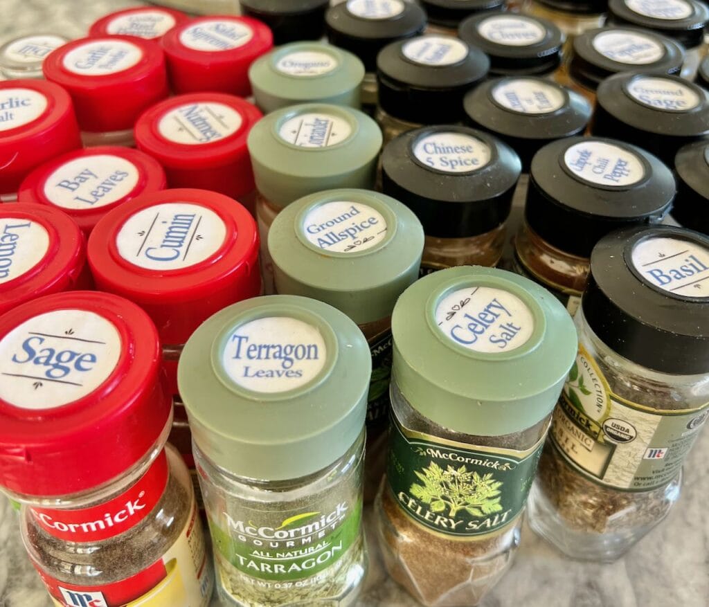 many spice bottles lined up with new labels on top of the lids