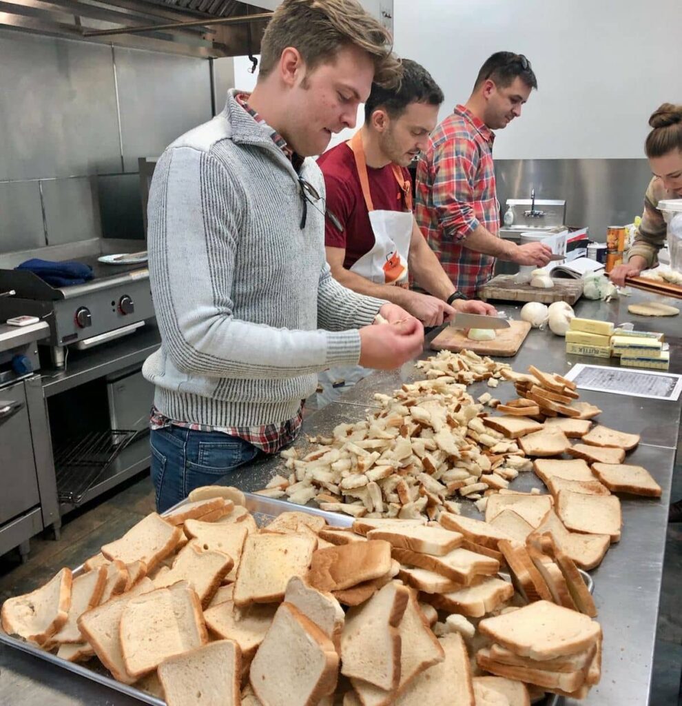 Three men preparing massive amounts of Thanksgiving stuffing