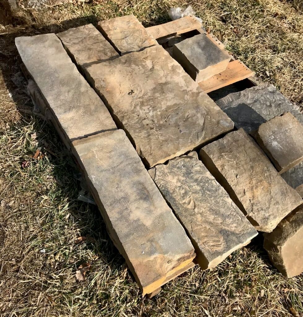 View of a pallet in the yard with seven stone arranged in a rectangle