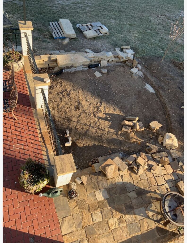 Overhead image of the DG patio worksite with retaining wall on the East  and stone walkway on the west