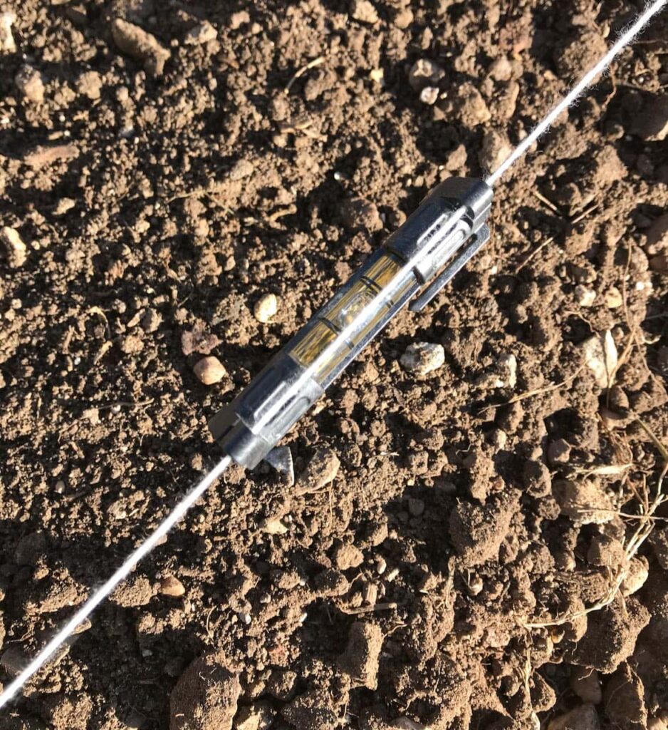 super closeup view of a string level suspend over brown dirt