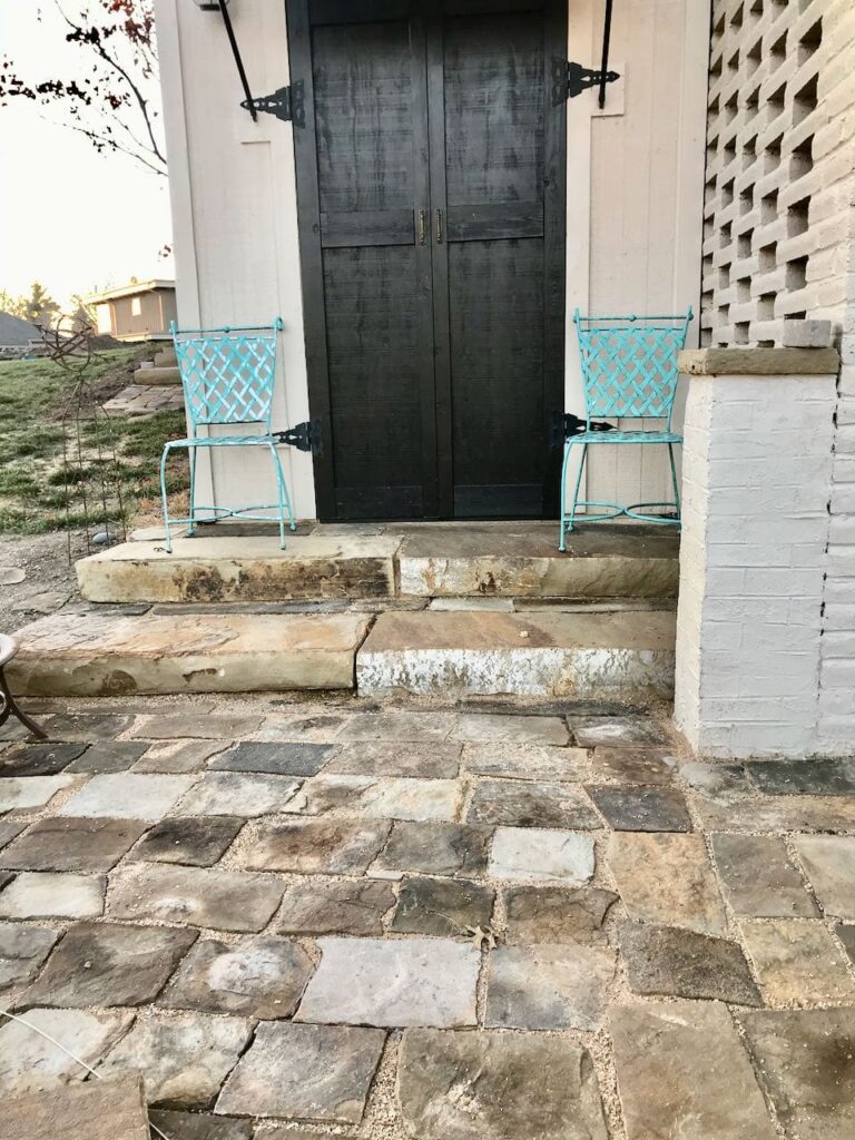 View of Tool C abana doors flanked by vintage iron chairs sitting on very large steps flush to shed floor height