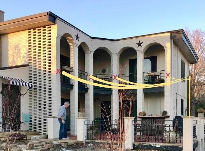 An image of the back of the house marked in four spots with red X's where the lights will connect and a thin line showing where each string of lights will swoop down to one pole in the outside corner of the patio