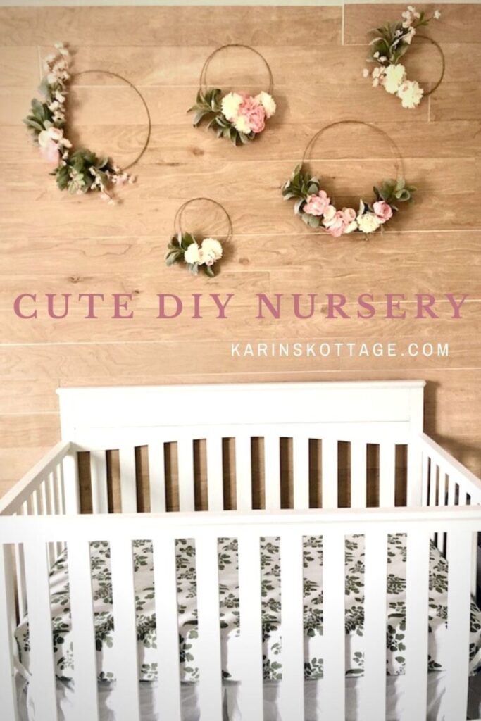 a wall in a nursery covered with natural wood shiplap and five hoop wreaths hanging above the side of a baby's crib