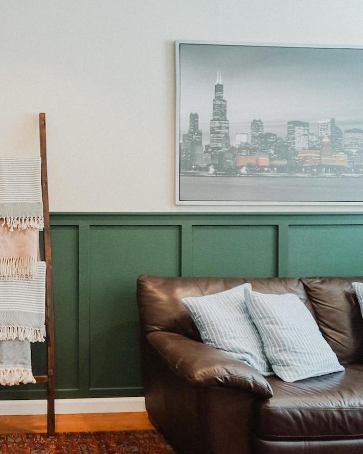 image of a board and batten wall installed behind a leather couch with a large painting above the board and batten 