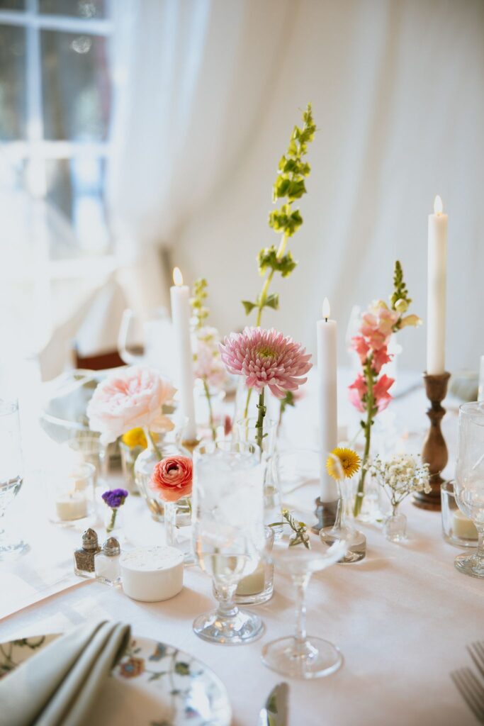 soft image of a cluster wedding centerpiece with white curtains and soft lighting behind