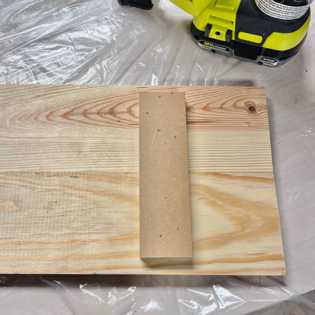 closeup of two boards held together with a piece of scrap wood nailed across them