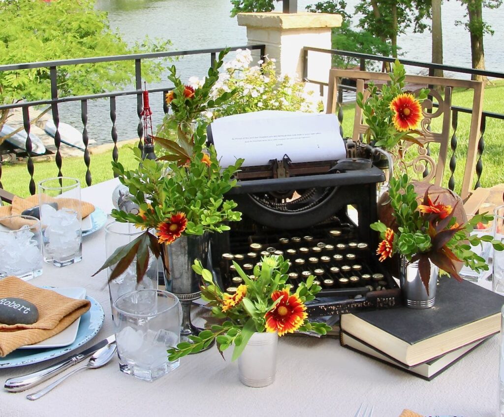 Closeup of the Father's Day centerpiece featuring a vintage typewriter, flowers and books