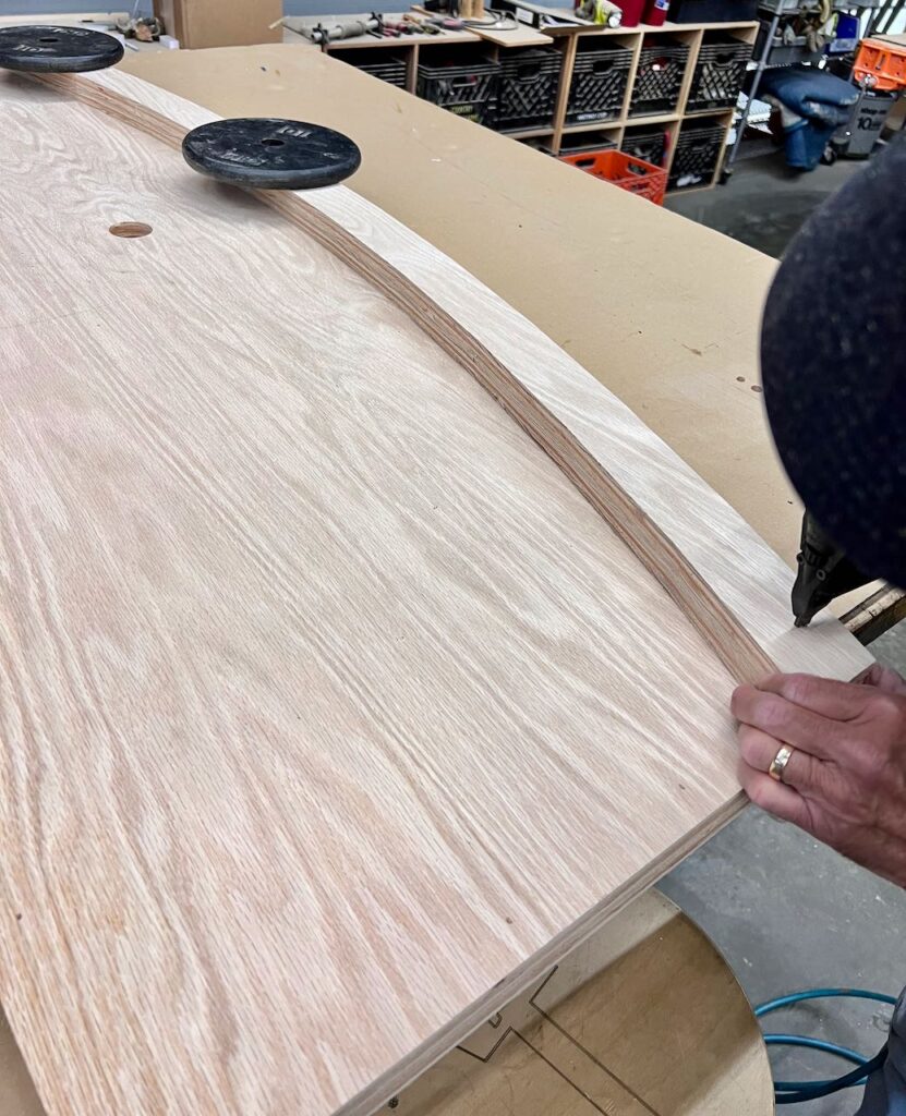 image of the bottom of the glued countertop with the apron glued on top and being brad nailed together