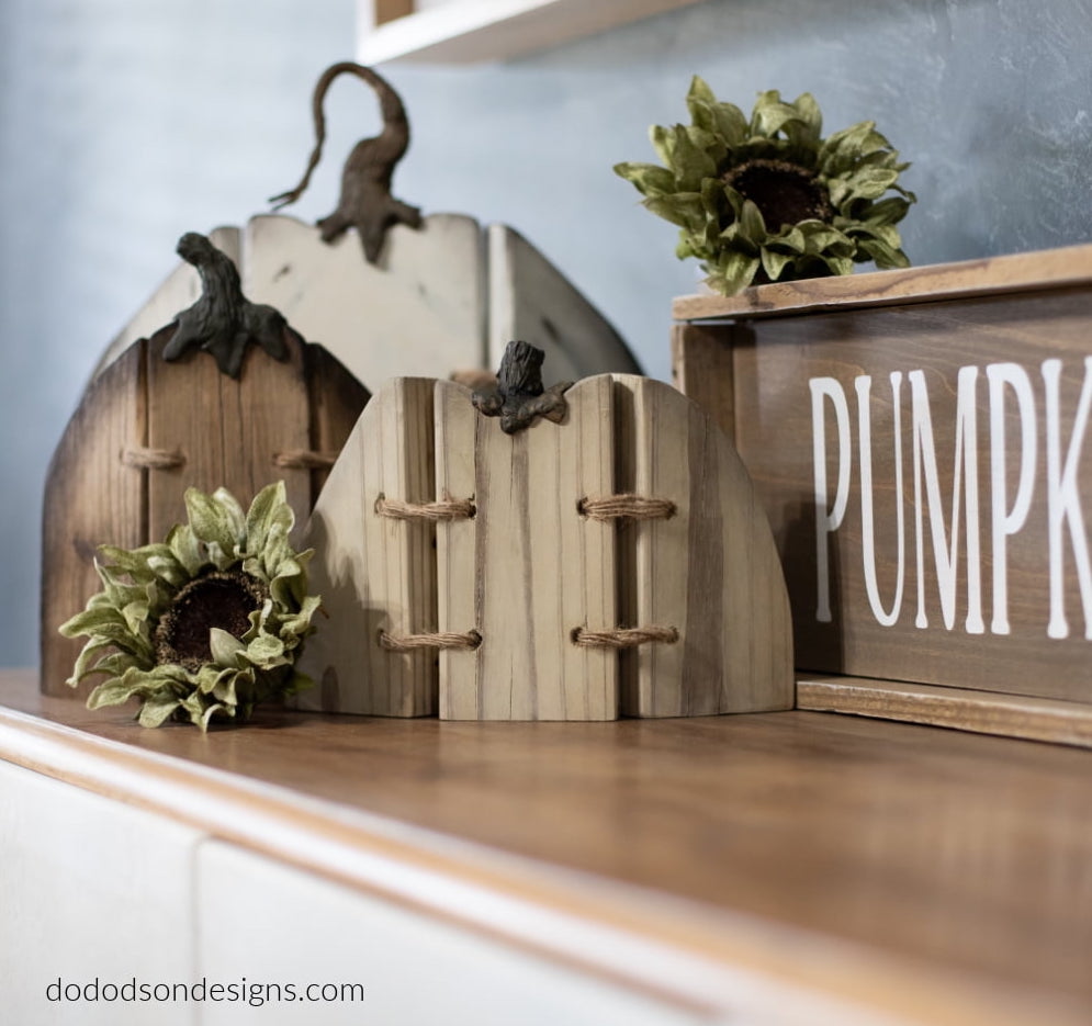 Display of three wood pumpkins that hinge with twine