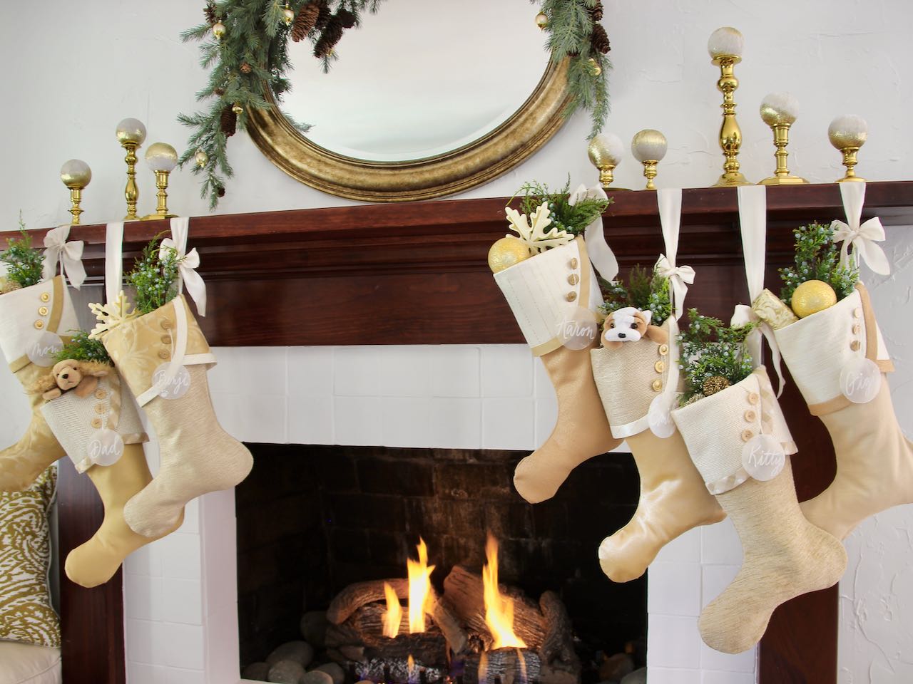 7 coordinating Christmas stockings with capiz shell name tags flanking a fireplace