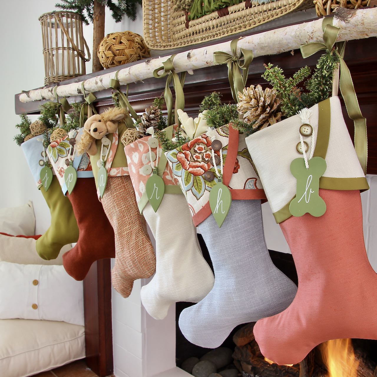 close angle view of colorful Cottage Christmas Stockings with green bulb name tagsi