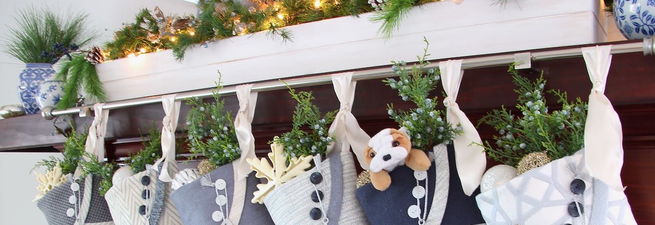 Set of stockings hanging from a silver rod attached to a wood mantel cover