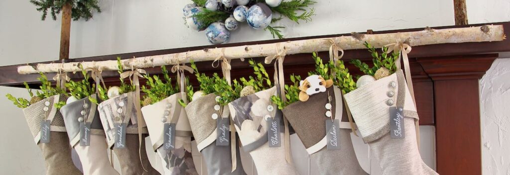 wide closeup of stockings hanging from a birch branch attached to mantel cover