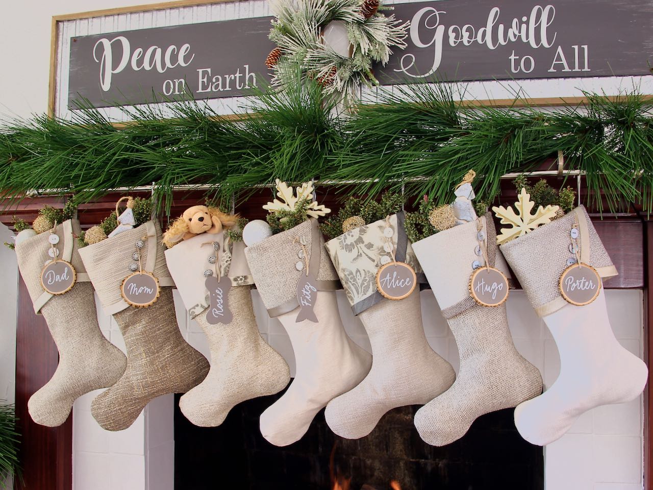 7 coordinating neutral Christmas stockings with greige tree slice tags