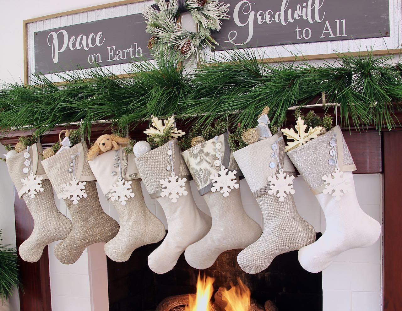 7 coordinating neutral Christmas stockings with snowflake name tags
