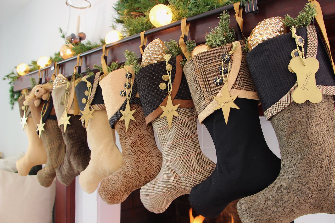angled view of 8 coordinating dark and formal Christmas stockings with gold star name tags