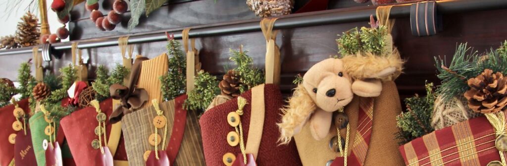 angle view of stockings hanging from a bronze rod held by cabinet knobs attached to a mantel cover