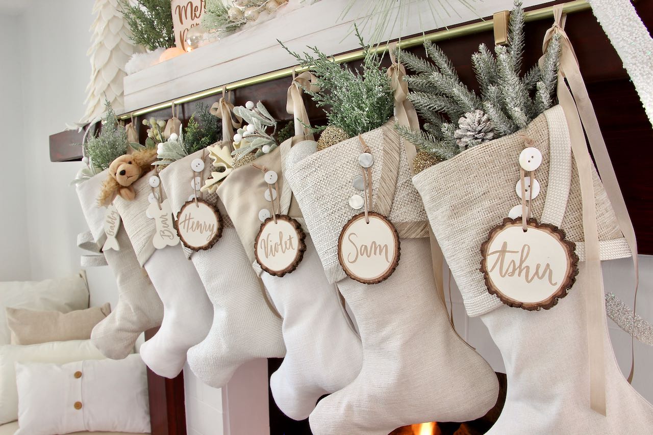 6 coordinating white Christmas stockings with white tree slice name tags