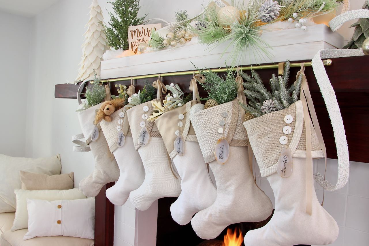 wide view of light neutral unique Christmas stockings on decorated mantel