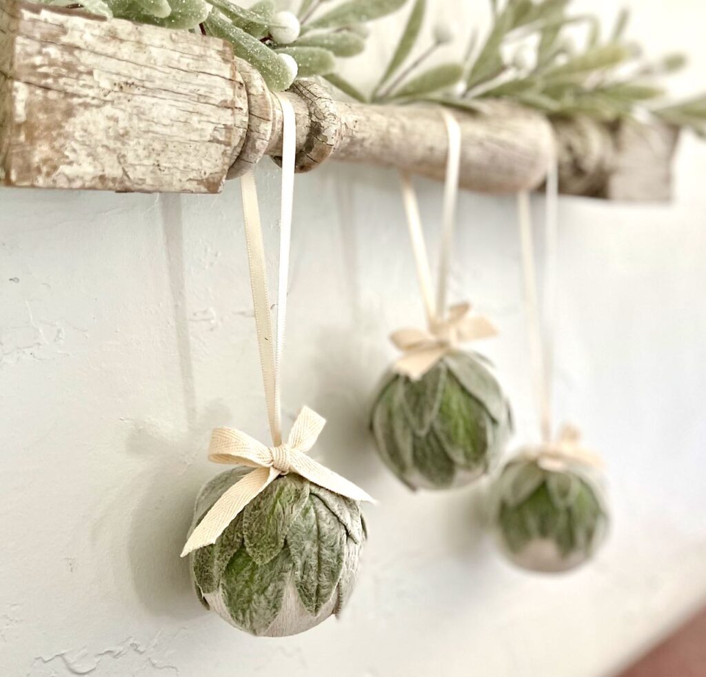 three Lambs ear Christmas bulbs shown hanging from a vintage spindle topped with mistletoe