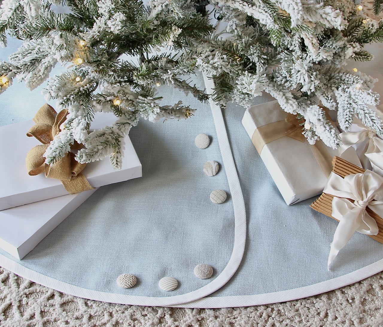 Pale blue linen trtee skirt banded. in white with kaki and white buttons under a flocked Christmas tree