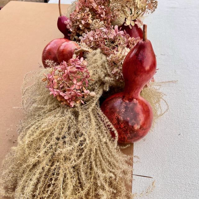 completed centerpiece on the edge of cardboard being transferred into place on a tablecloth