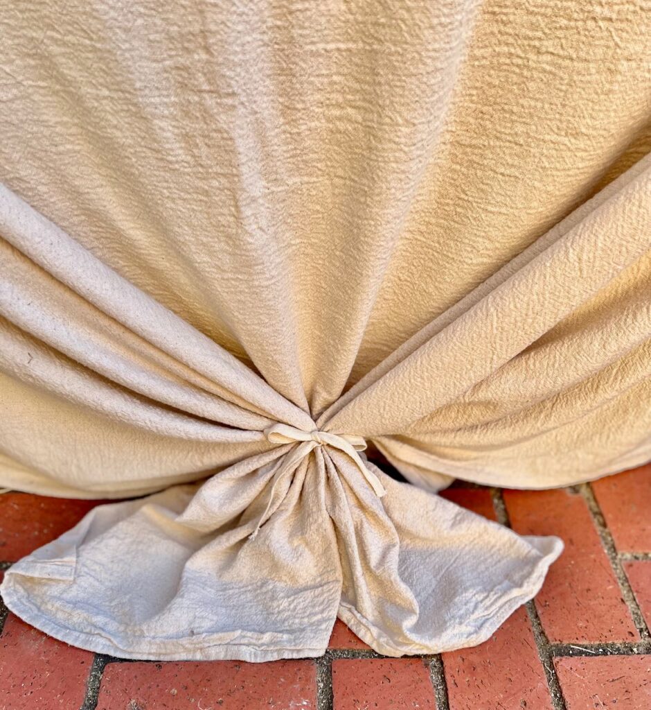 closeup of the ends of the tablecloth bundles together and tied with webbing