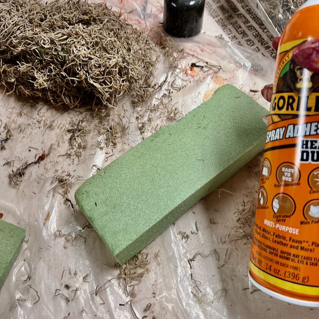 a covered piece of foam, a bare piece of foam and the can of spray glue