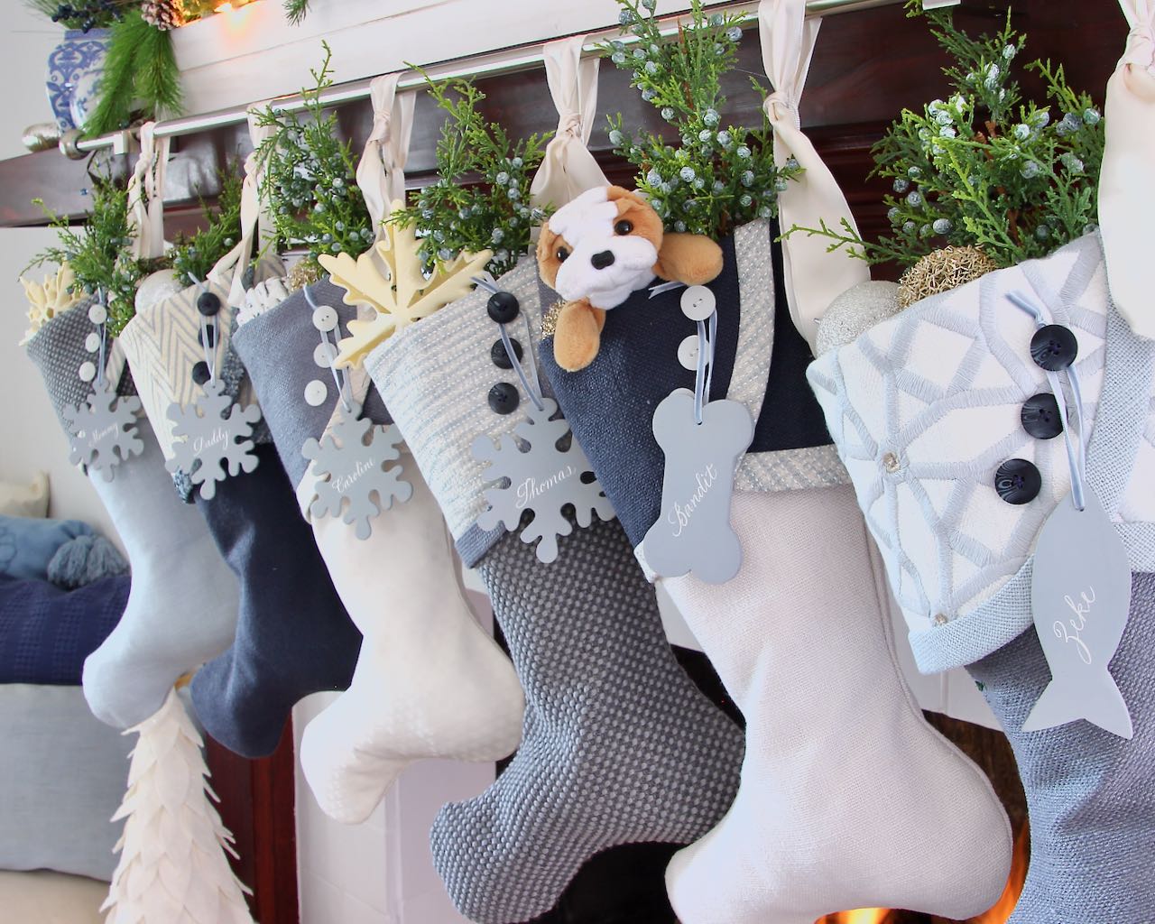 Blue Christmas Stockings hanging in a row from a dark wood mantel
