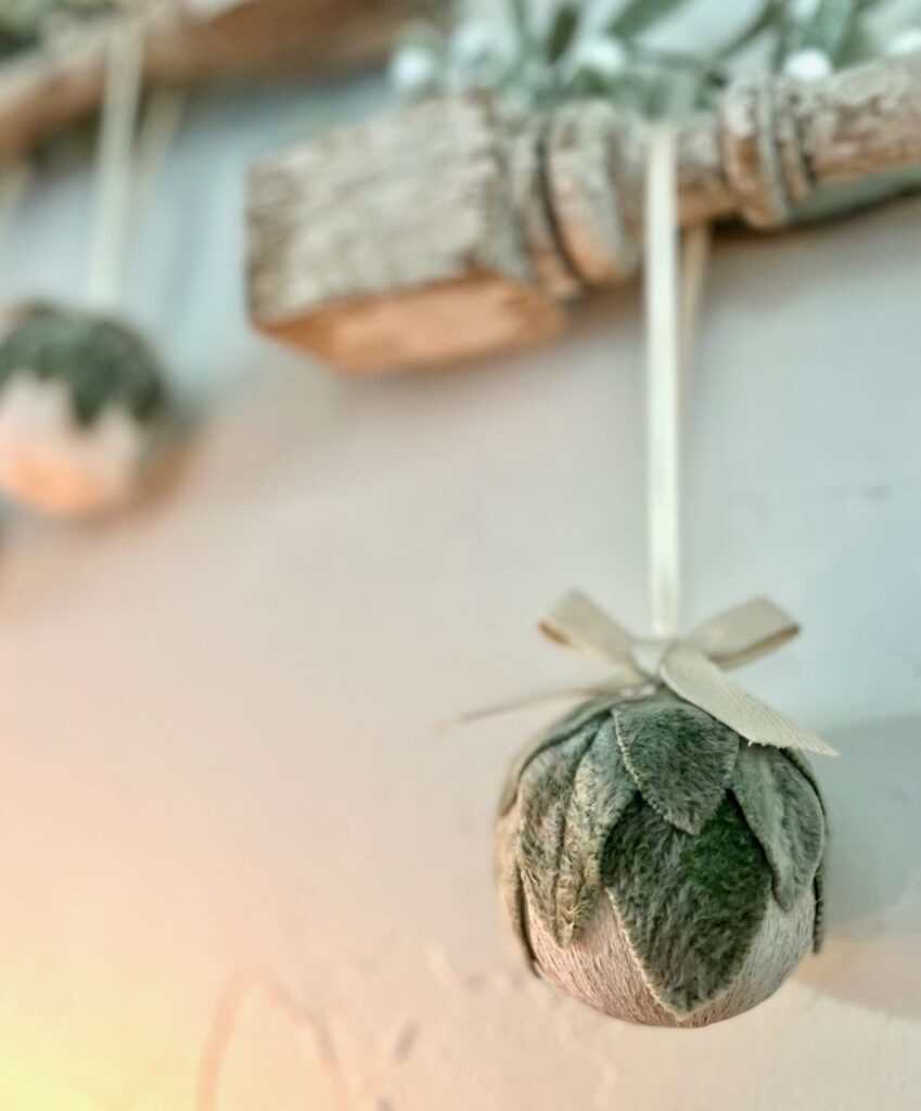 view of a lambs ear ornament hanging from a vintage wood spindle on a white wall