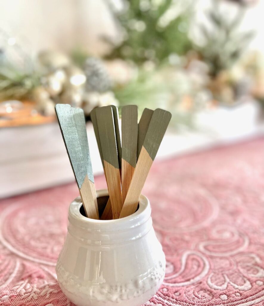 closeup of bamboo flatware withh th e handles painted sticking out of a white sugar bowl