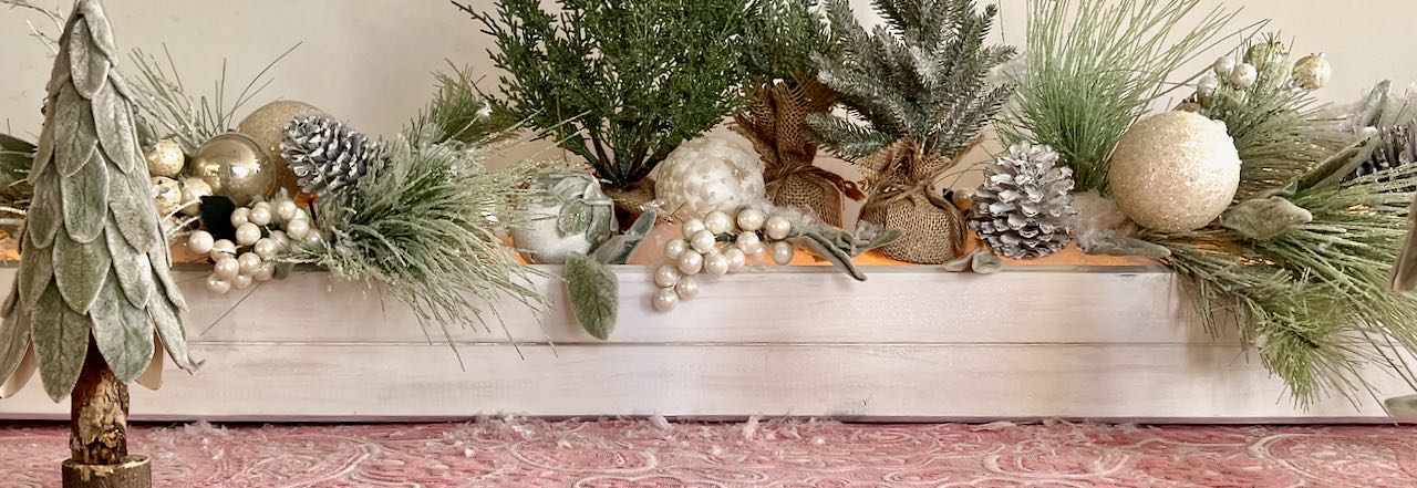 wide closeup of low, long wood box overflowing with trees, bulbs, berries and branchhes