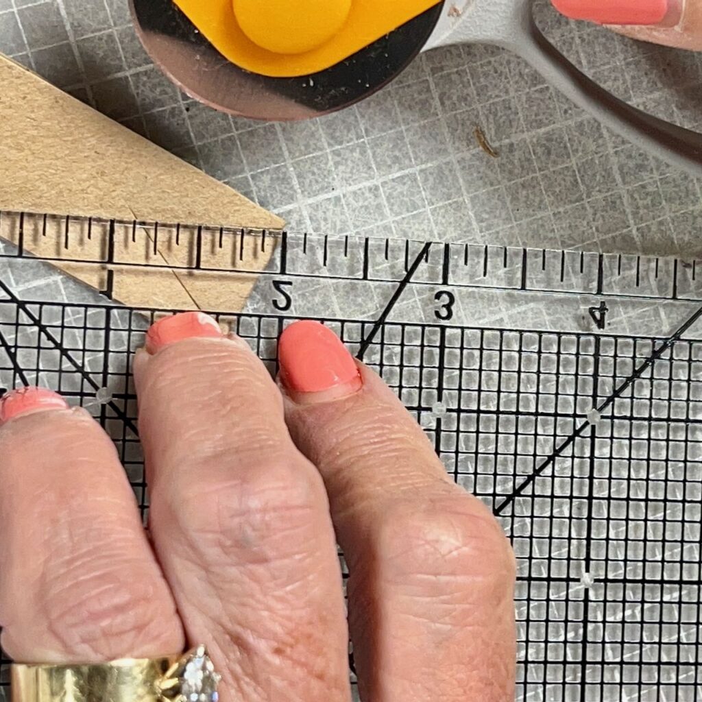 fingers holding a ruler from the corner to the center point for