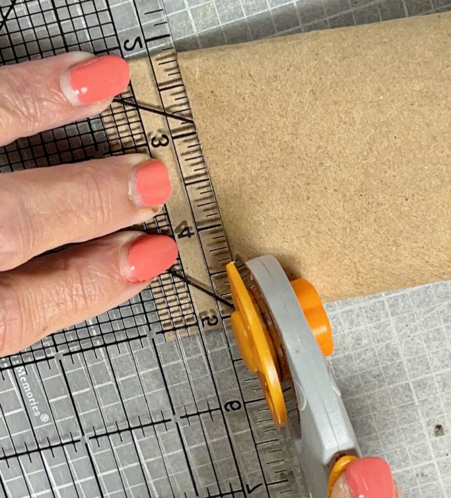 woman's fingers holding the ruler to guide the rotary cutter