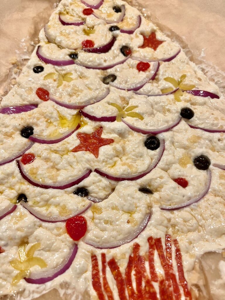 the dough. is decorated, dimpled and slicked with olive oil