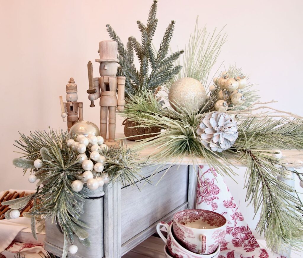 Top of the Christmas cookie display with greenery, bulbs and two wood nutcrackers