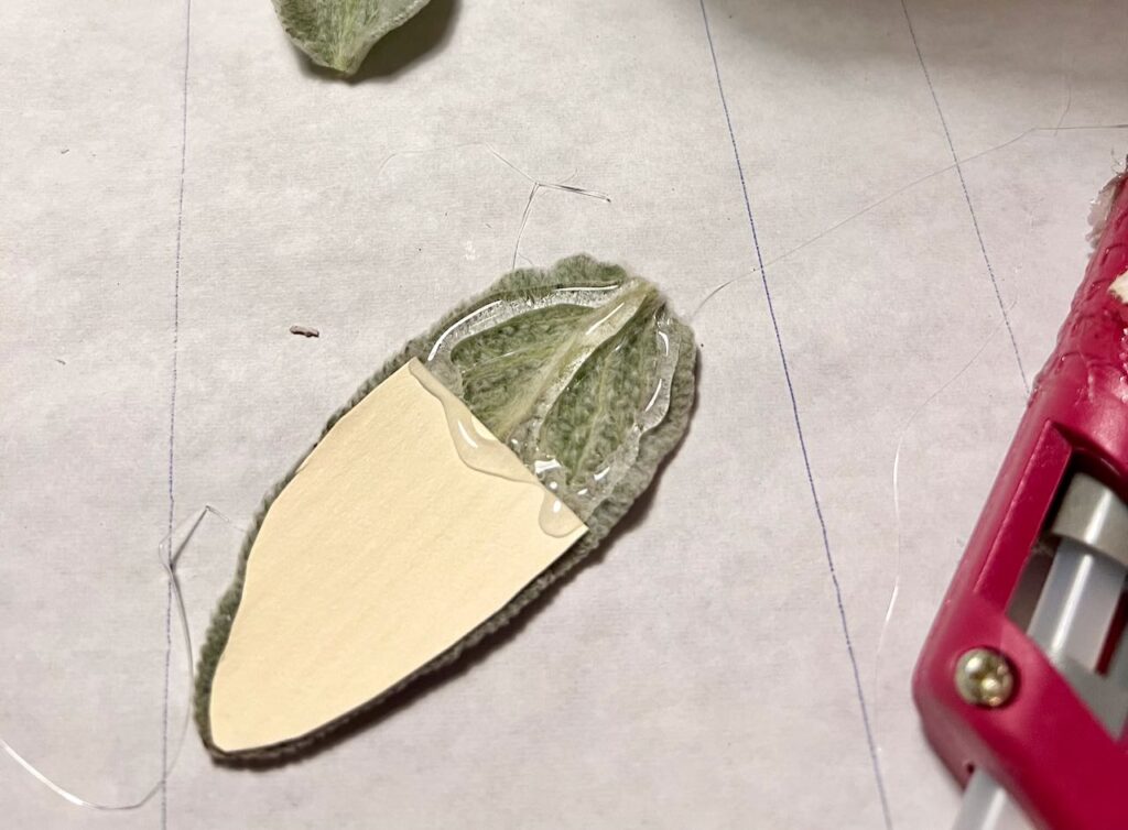 closeup of one leaf backed with stiff paper and hot glue on the top third