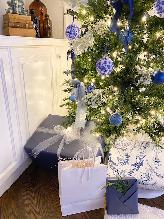 Part of a Christmas tre by newly painted built-ins and packages under the tree