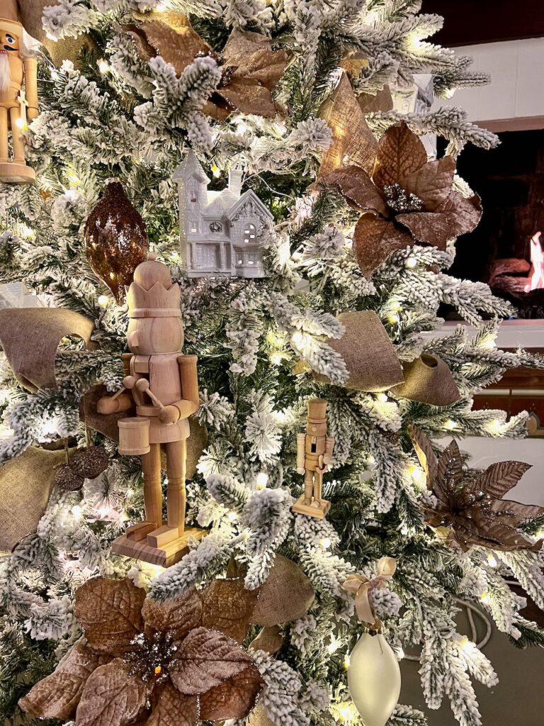 closeup of nutcrackers, a ceramic house and linen ribbon beside a fire in the fireplace