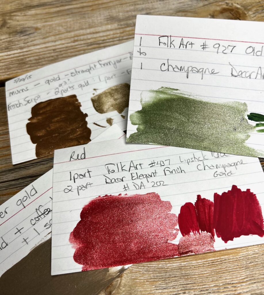four notecards with samples of paint and handwriting of the mixtures that produced the colors