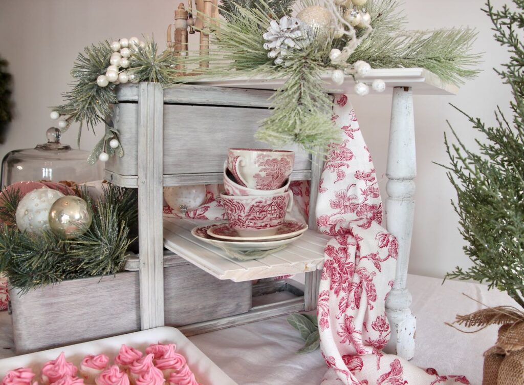 Right side of the Christ mas cookie display showing the vintage spindle holding the shelf and transferware cups and saucers on the low shelf