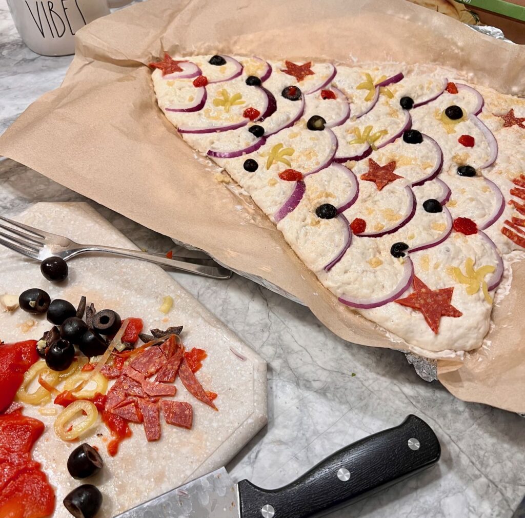 slivers and scraps of toppings next to the decorated Christmas tree dough