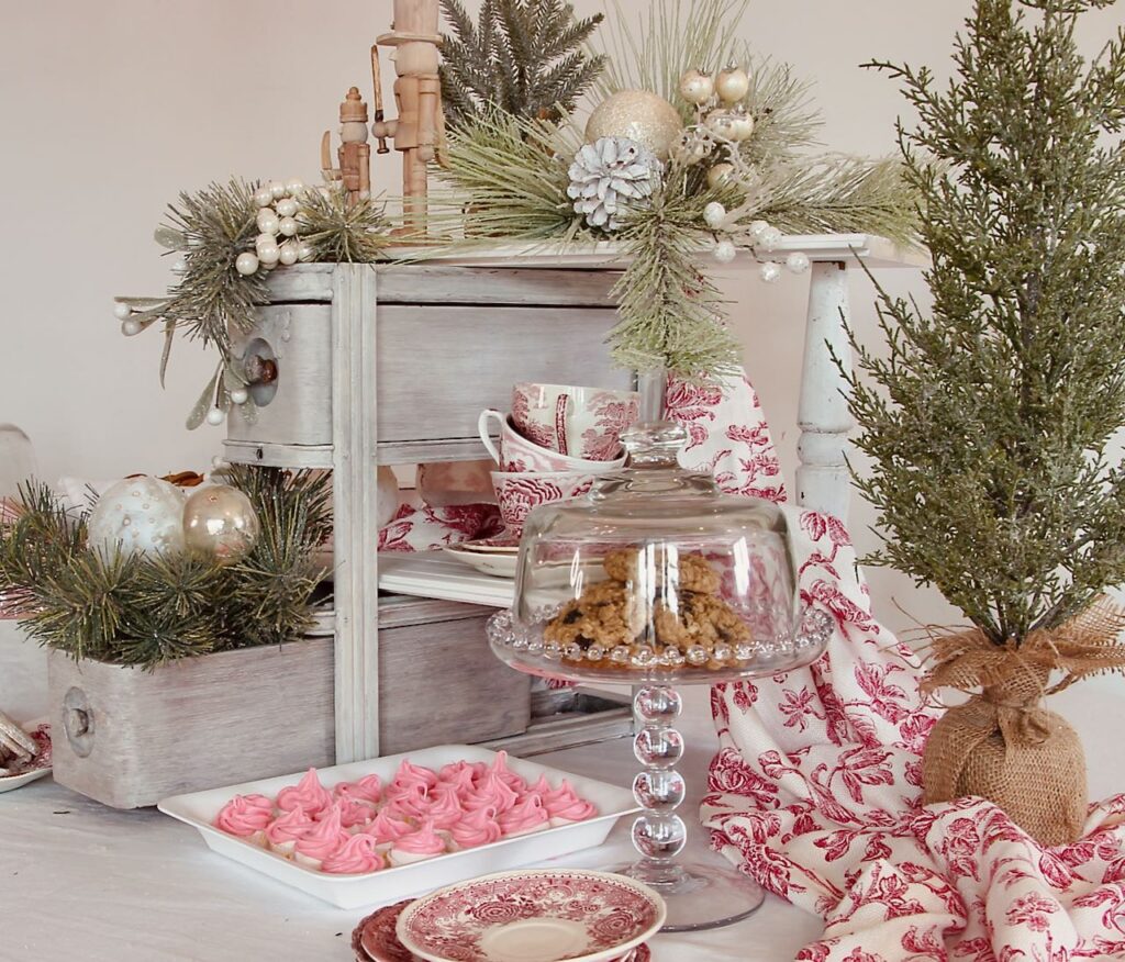 Right side of the Christmas cookie display with a decorative tree and winter greens and bulbs spilling out of the lowest open drawer