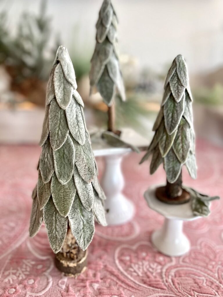 Three lambs ear small Christmas trees perched on cupcake holders